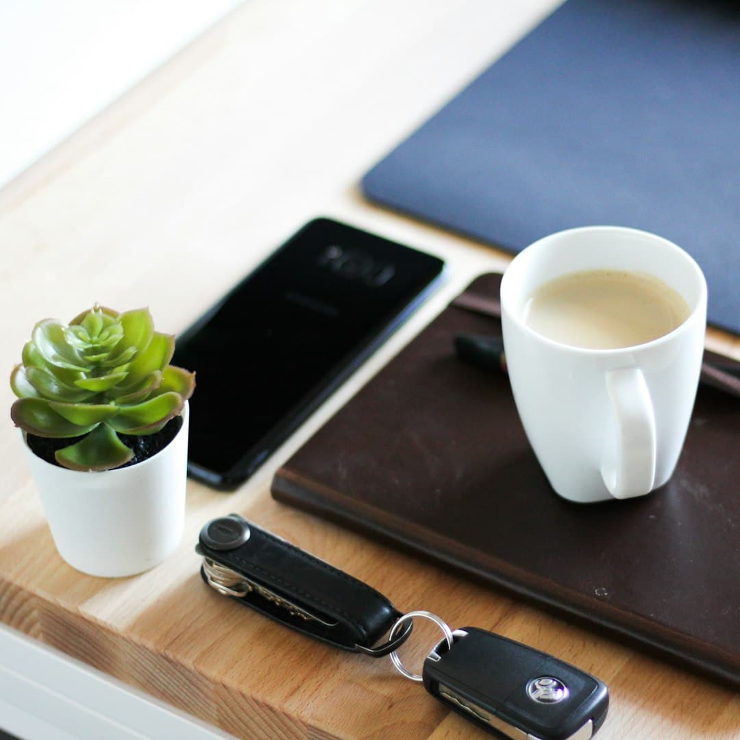 Desk with tech gadgets including a keyboard, charger, and wireless speaker